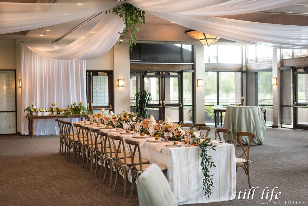 an indoor winter wedding reception with white drapery decor lining the ceiling